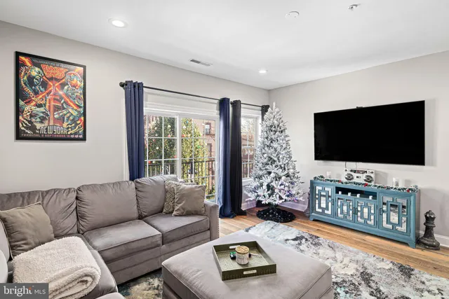 a living room with furniture a flat screen tv and a flat screen tv