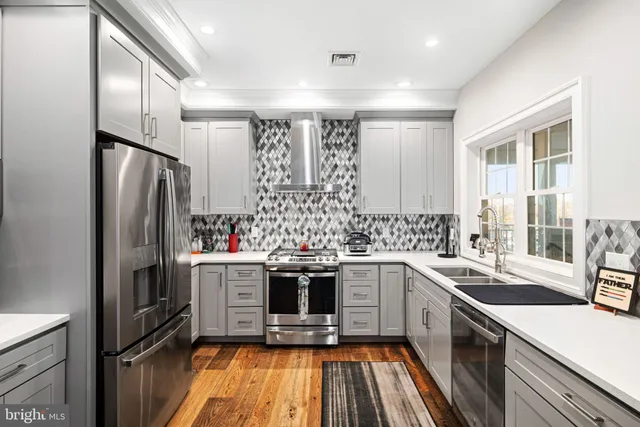 a kitchen with a sink cabinets stainless steel appliances and a window