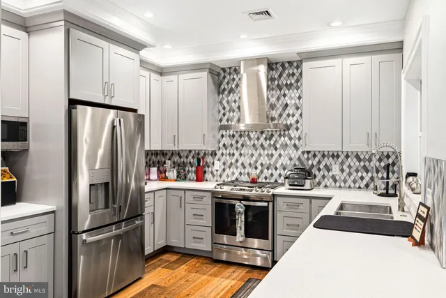 a kitchen with stainless steel appliances a refrigerator and a stove top oven