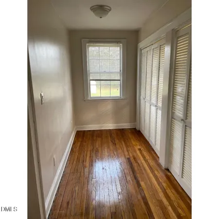 a view of a room with wooden floor and window
