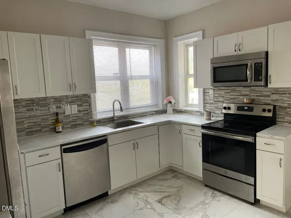 a kitchen with white cabinets and a sink