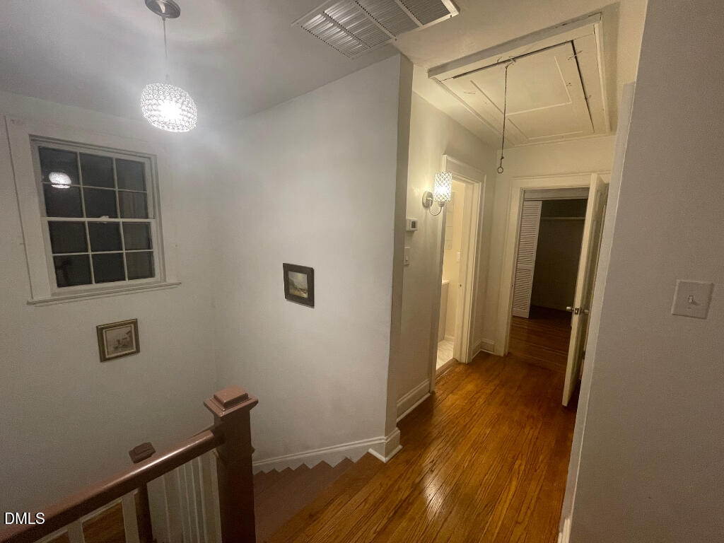 1609 Main Street Scotland Neck, NC 27874 - Photo 19 of 24 a view of a hallway with wooden floor and a bathroom