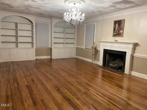 wooden floor fireplace and windows in an empty room