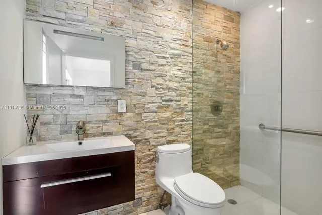 a bathroom with a toilet a sink and mirror