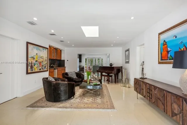 a living room with furniture a dining table and kitchen view