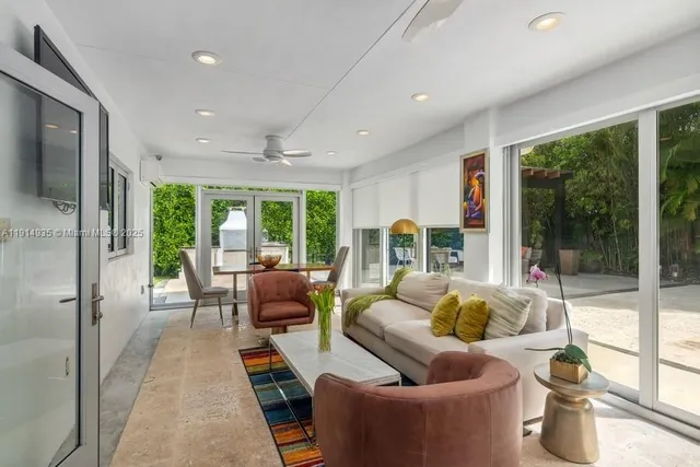 a living room with furniture and a floor to ceiling window