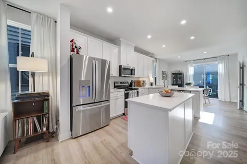 a kitchen with kitchen island a refrigerator and a stove top oven