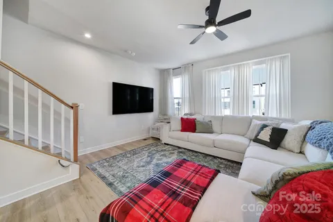 a living room with furniture kitchen area and a refrigerator