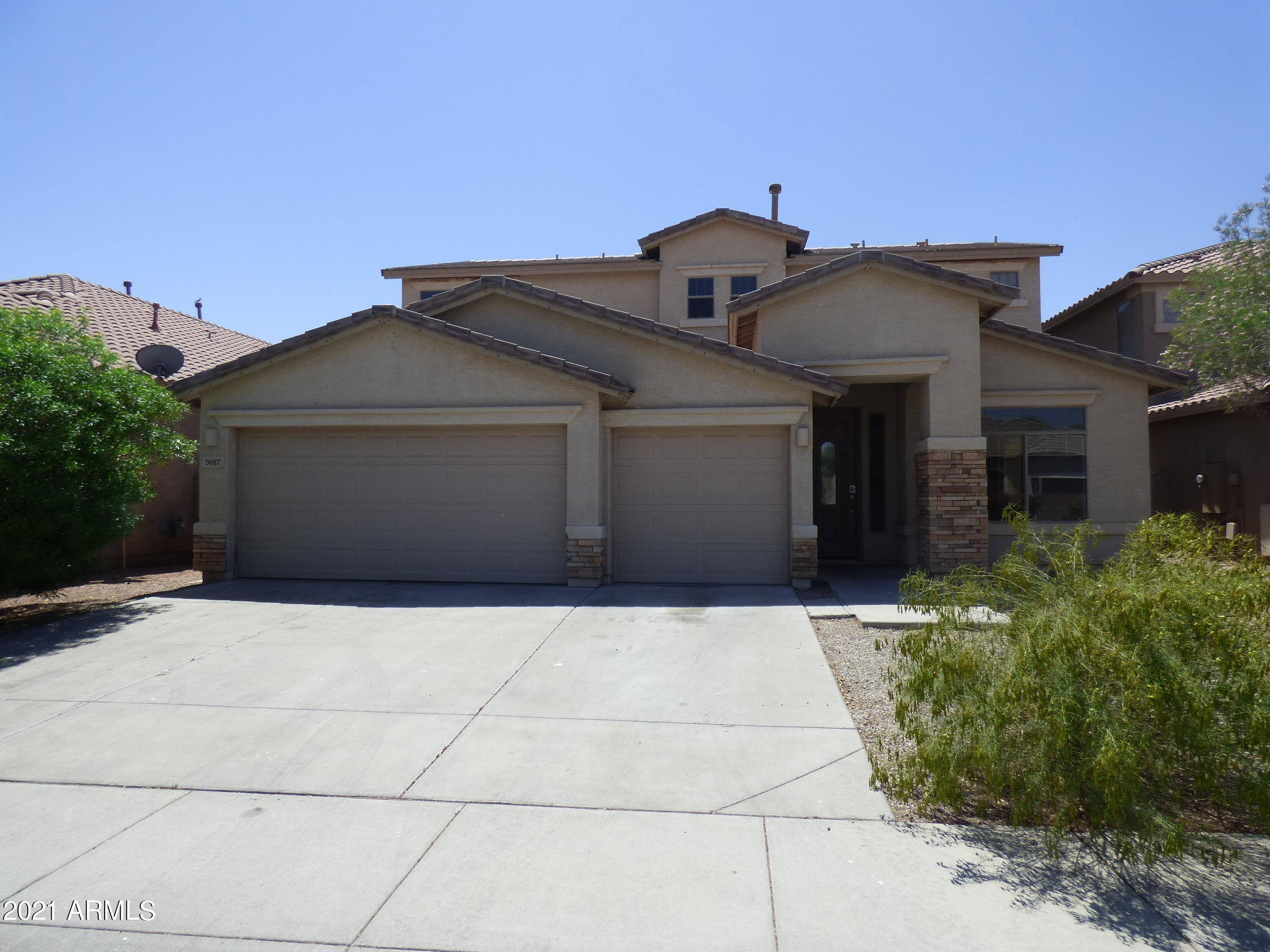 5617 West Carson Road Laveen, AZ 85339 - Photo 1 of 56 a front view of a house with a yard and garage
