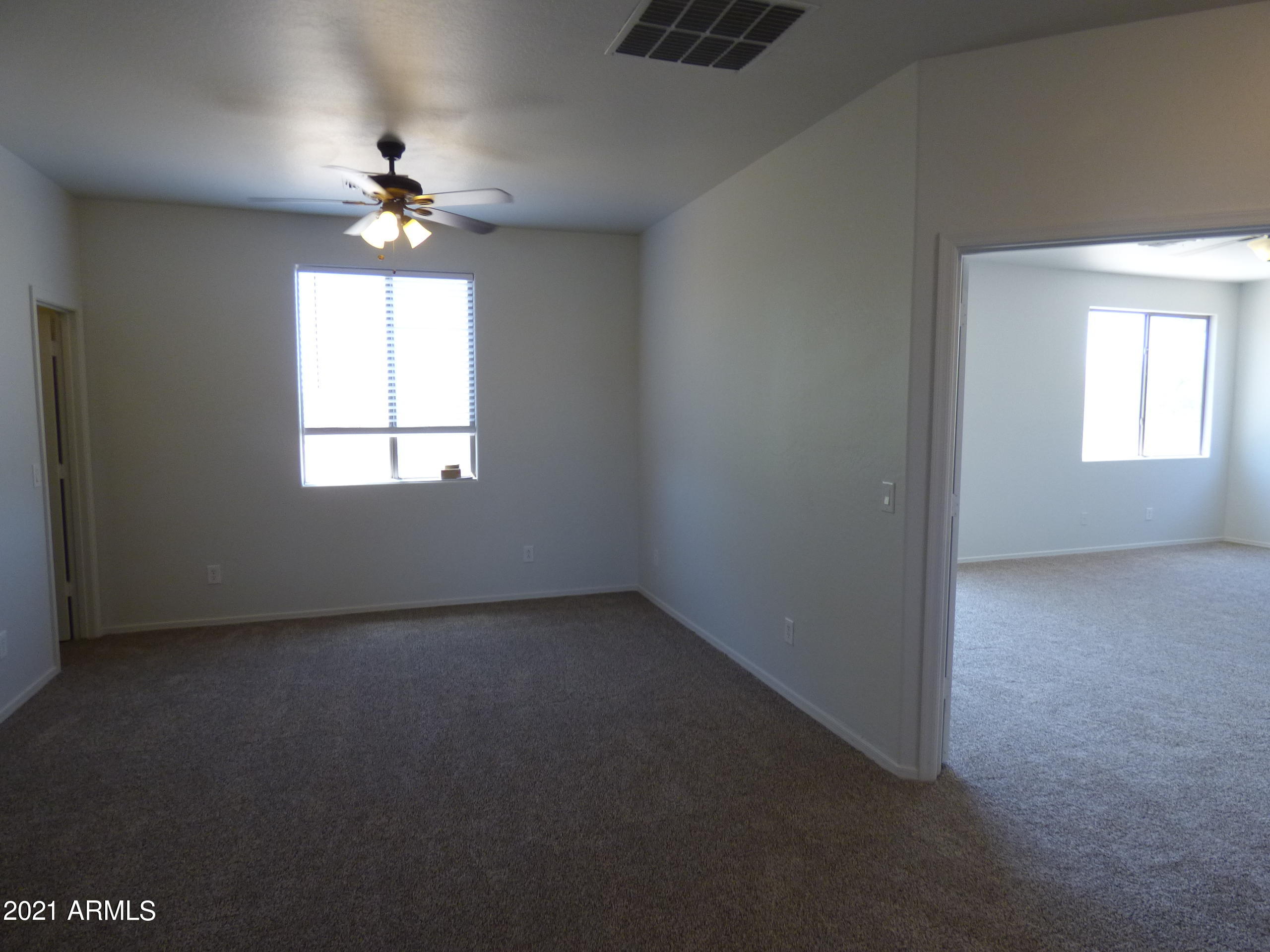 5617 West Carson Road Laveen, AZ 85339 - Photo 41 of 56 an empty room with chandelier fan and windows