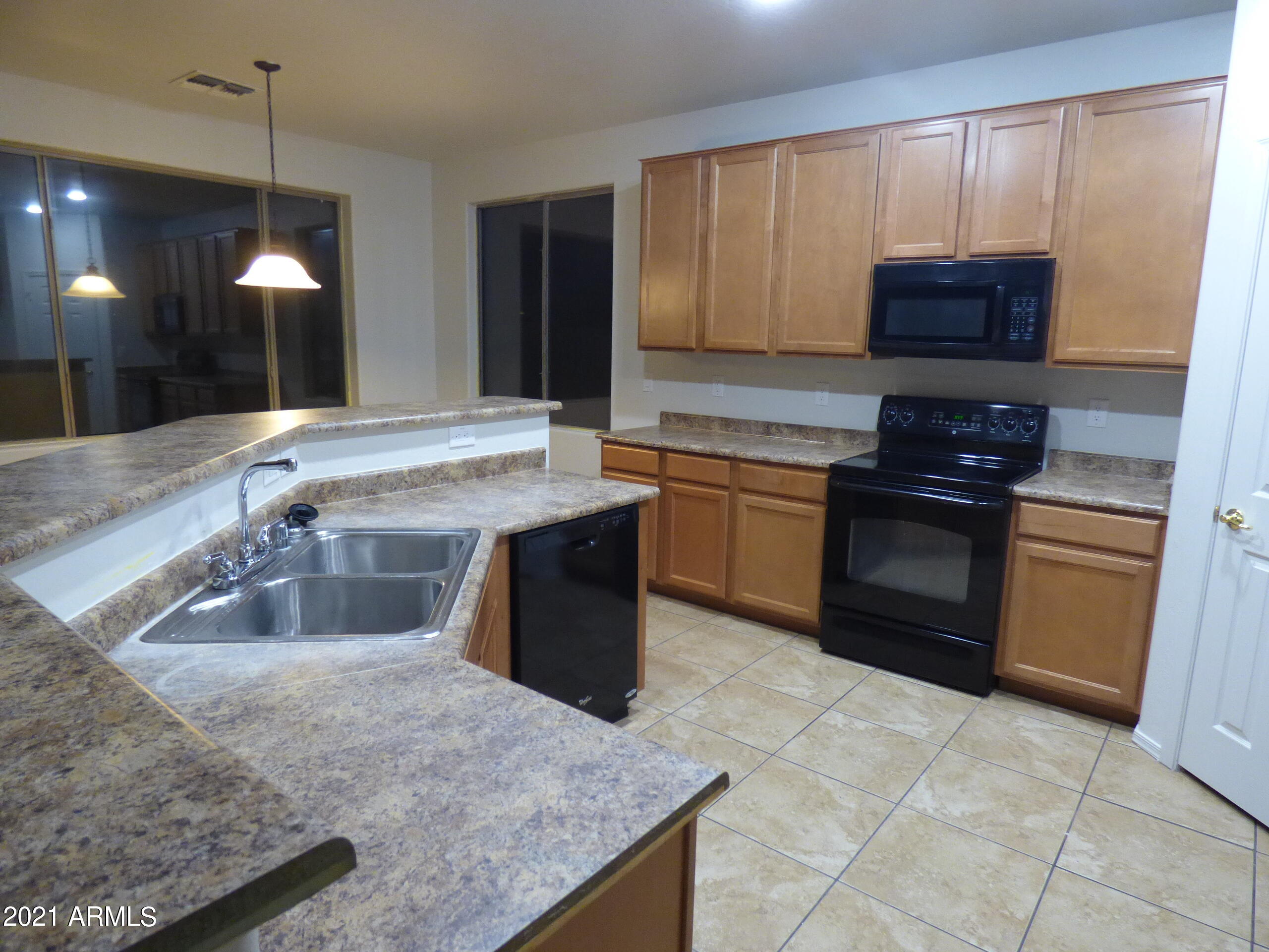 5617 West Carson Road Laveen, AZ 85339 - Photo 10 of 56 a kitchen with stainless steel appliances granite countertop a stove a sink and a microwave
