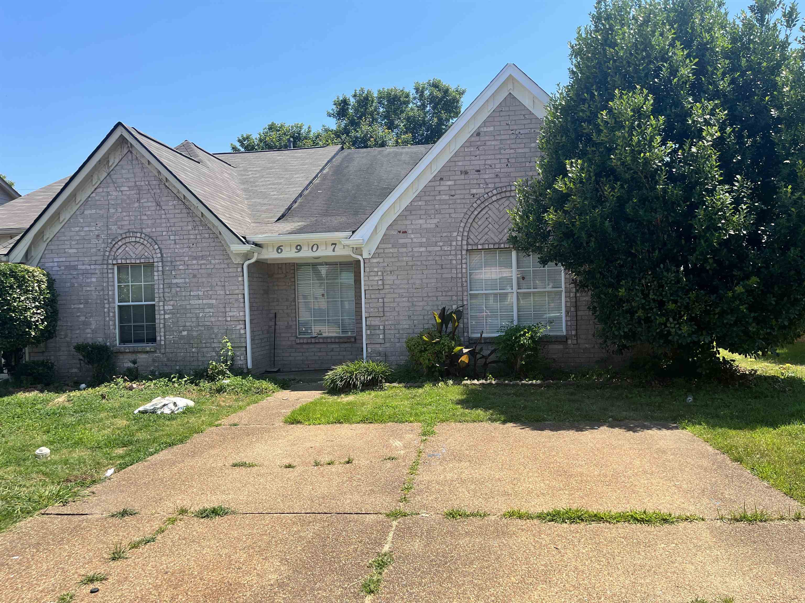 6907 Snyder Road Memphis, TN 38141 - Photo 1 of 1 a front view of a house with a yard and garage