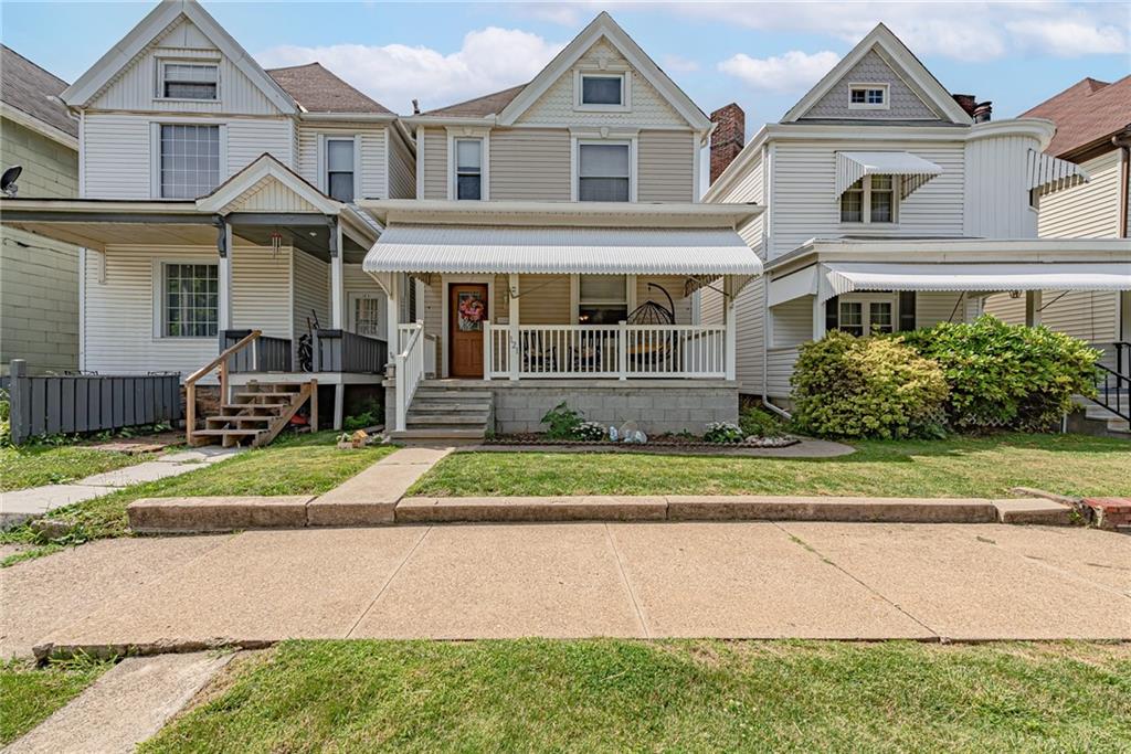 a front view of a house with a yard and potted plants