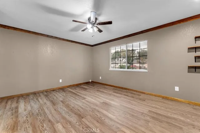 a view of an empty room with a window and wooden floor