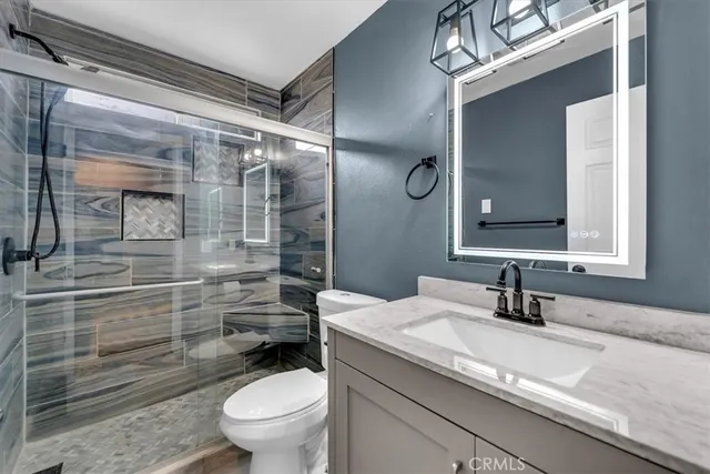 a bathroom with a granite countertop sink toilet and shower