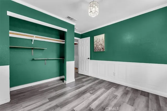 a view of empty room with window and wooden floor