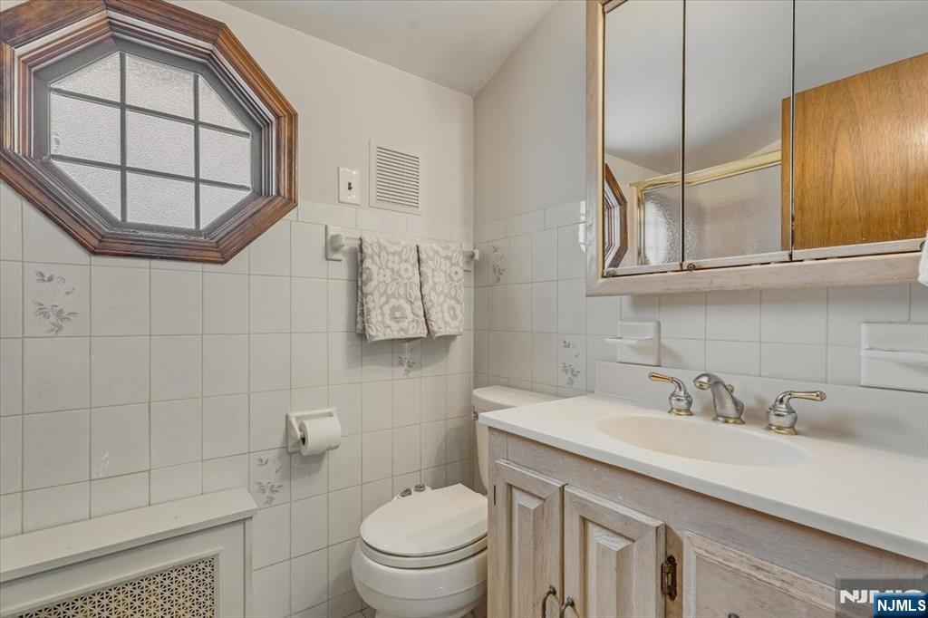 27 Prospect Avenue Pompton Plains, NJ 07444 - Photo 18 of 26 a bathroom with a granite countertop sink a toilet and mirror
