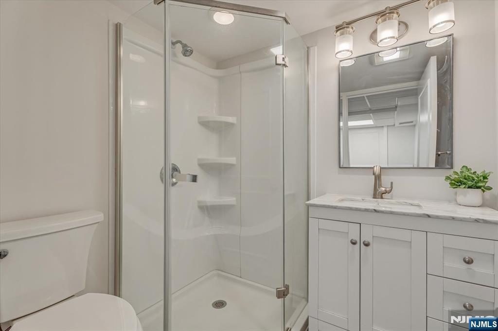 27 Prospect Avenue Pompton Plains, NJ 07444 - Photo 21 of 26 a bathroom with a shower sink vanity and mirror