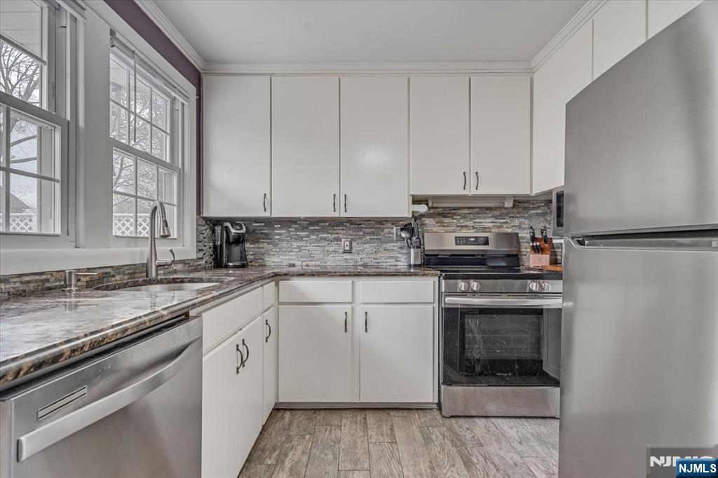 27 Prospect Avenue Pompton Plains, NJ 07444 - Photo 10 of 26 a kitchen with stainless steel appliances granite countertop a stove and white cabinets