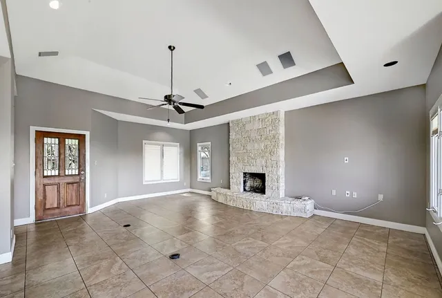 a view of empty room with a fireplace and windows