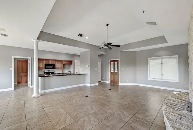 a view of an empty room with window and fire place