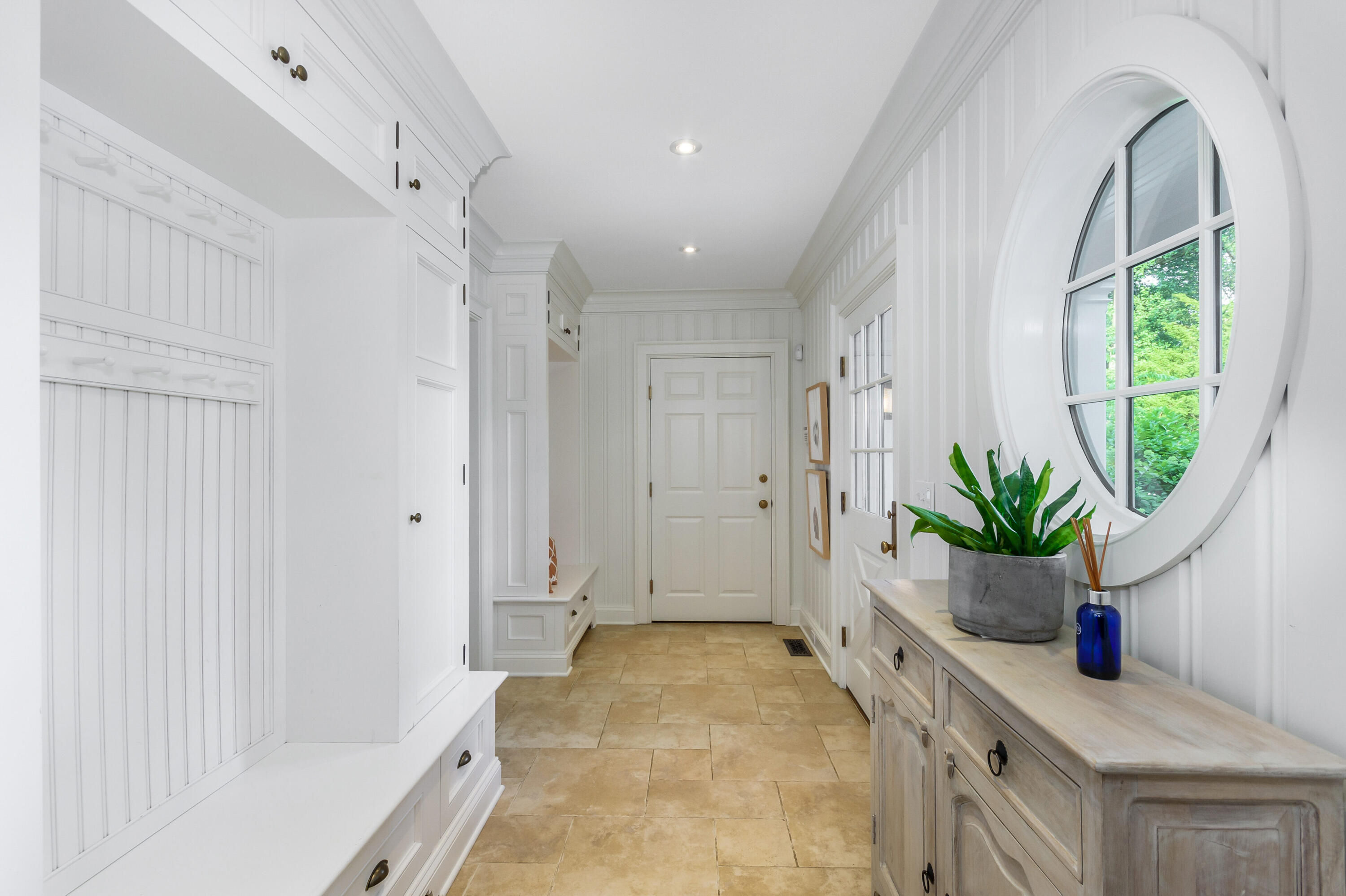 9 Sylvan Road Darien, CT 06820 - Photo 18 of 39 a hallway with a potted plant on the counter and a chair