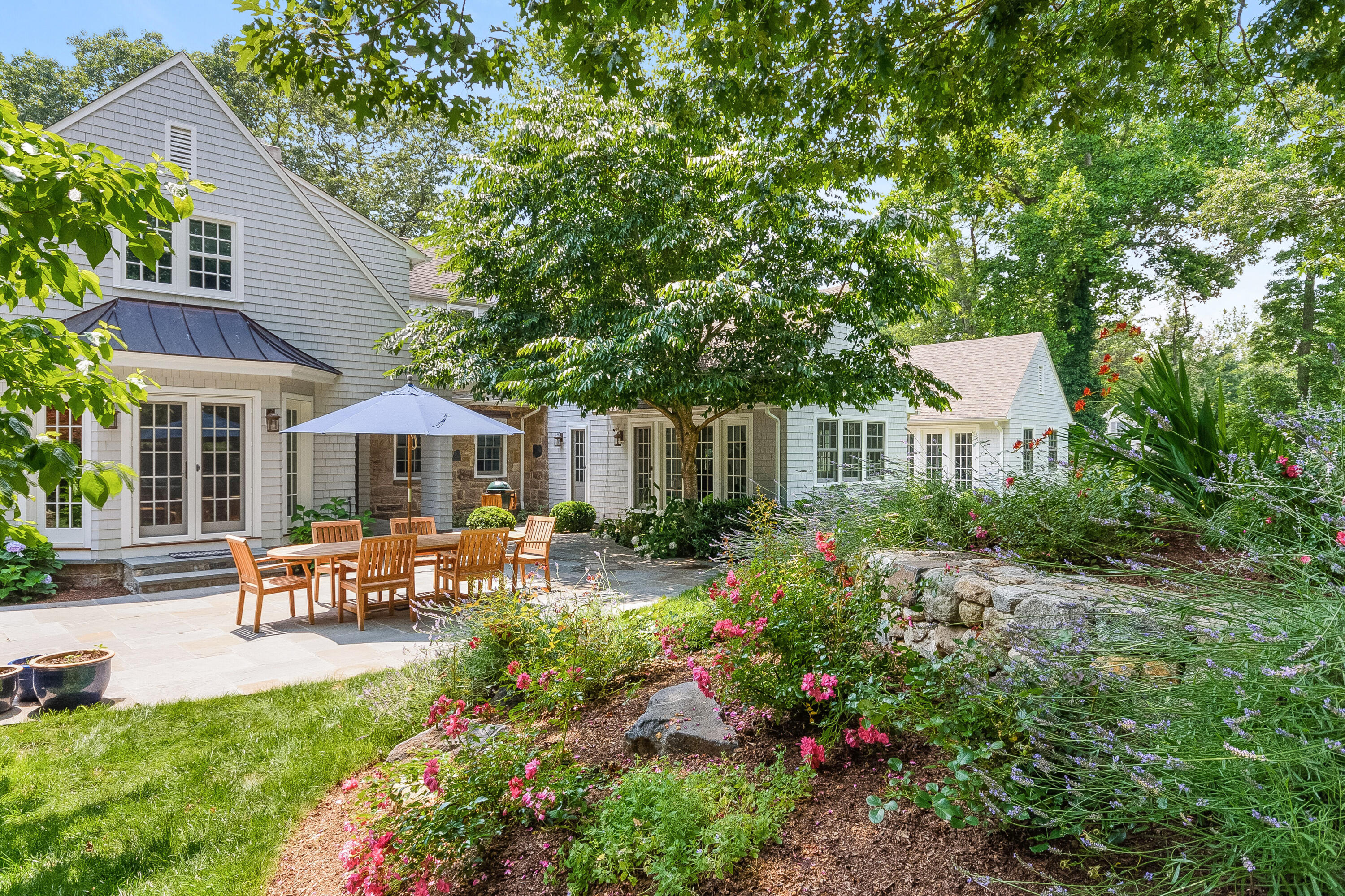 9 Sylvan Road Darien, CT 06820 - Photo 32 of 39 a view of a patio with table and chairs under an umbrella