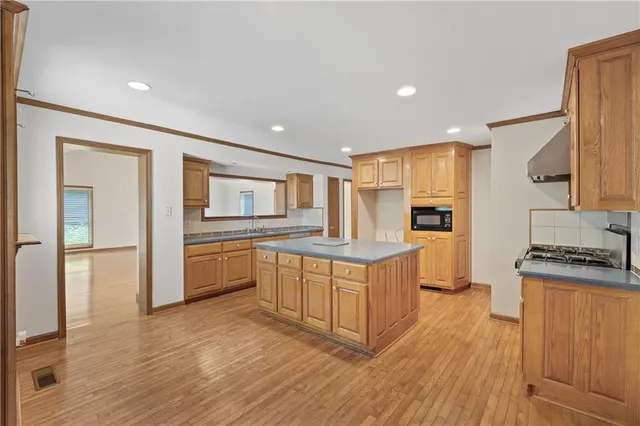 a kitchen with stainless steel appliances granite countertop a stove a sink and a refrigerator