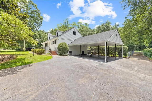 a view of a house with a big yard and large trees