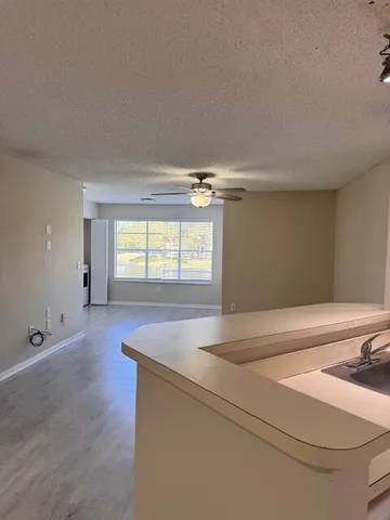 an empty room with a ceiling fan and window