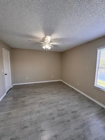 a view of an empty room with closet and a window