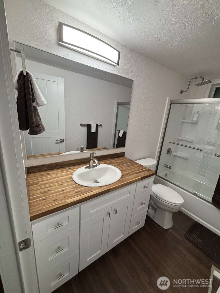12615 Northeast 189th Street Bothell, WA 98011 - Photo 31 of 40 a bathroom with a granite countertop sink a toilet and a mirror