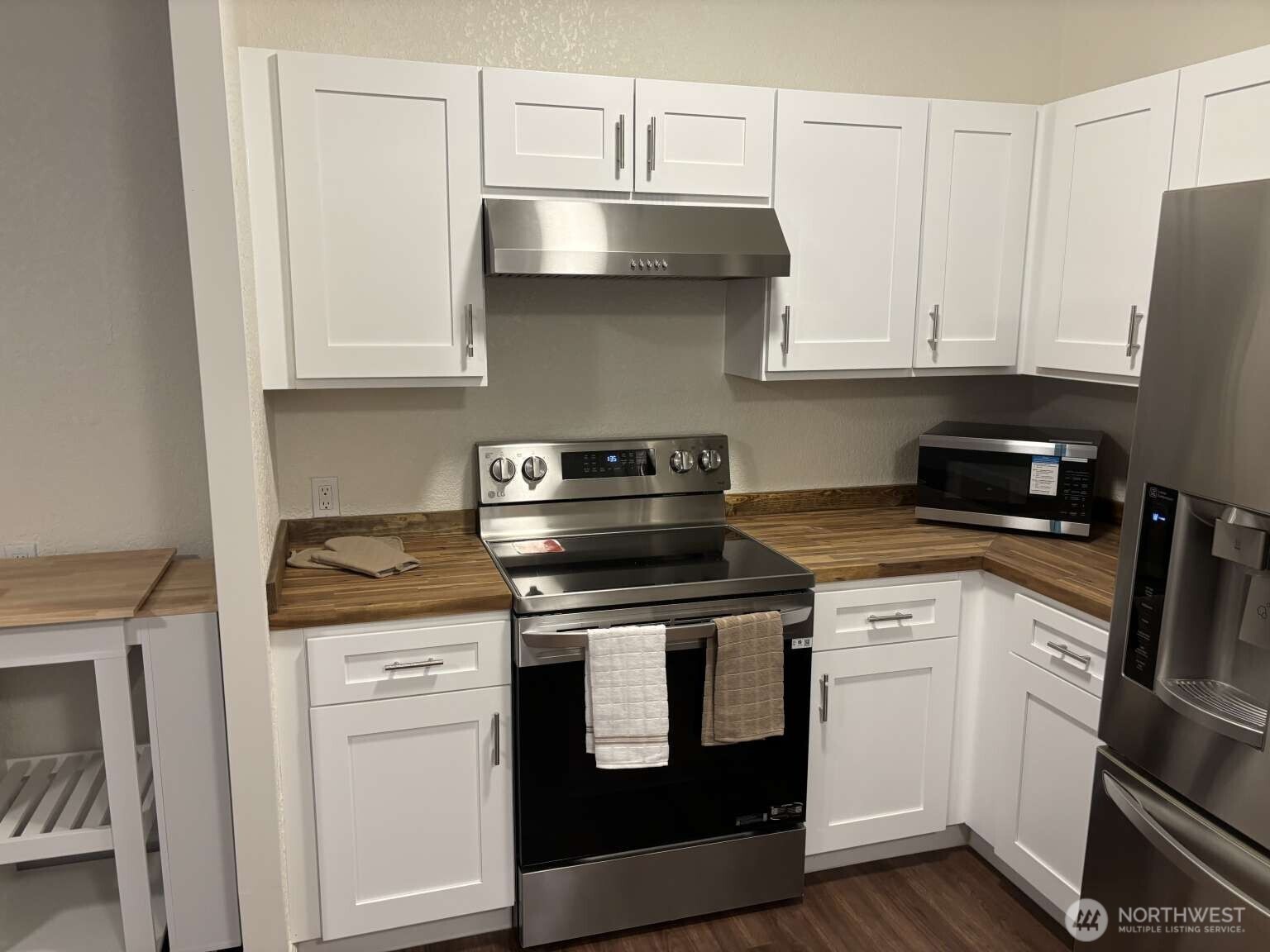12615 Northeast 189th Street Bothell, WA 98011 - Photo 10 of 40 a kitchen with granite countertop white cabinets and stainless steel appliances