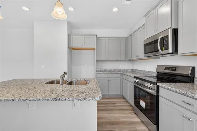 a kitchen with stainless steel appliances granite countertop a sink and a stove top oven