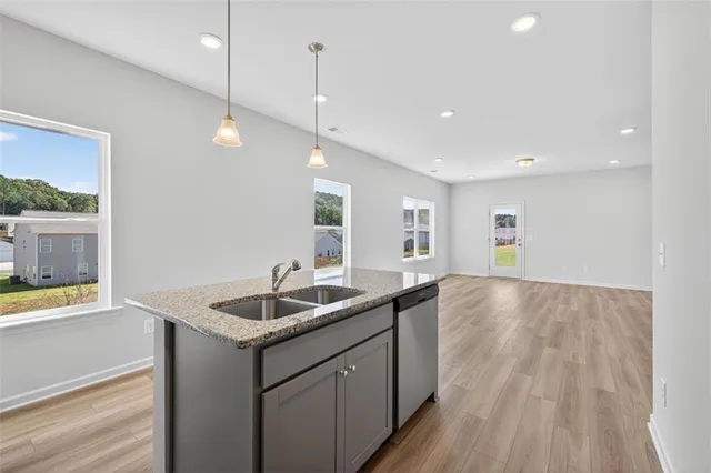 a kitchen with stainless steel appliances granite countertop a sink a oven and wooden floors