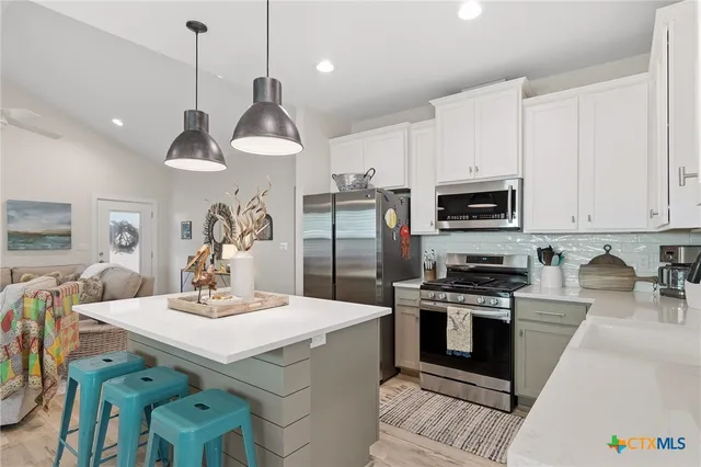 a kitchen with a sink a stove and chairs