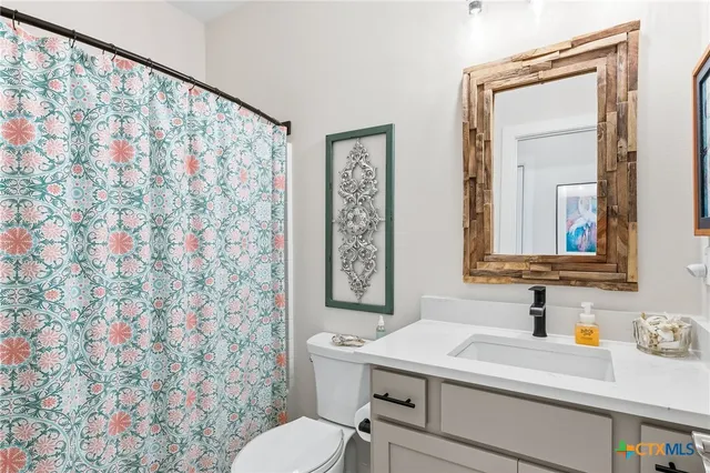 a bathroom with a sink a toilet and mirror