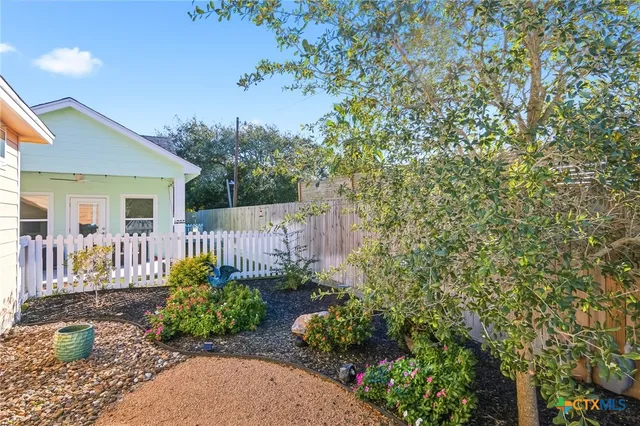a garden with plants in front of house