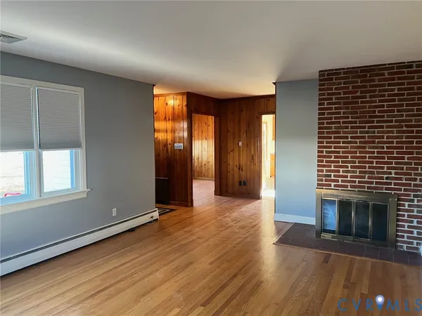an empty room with windows and a fireplace