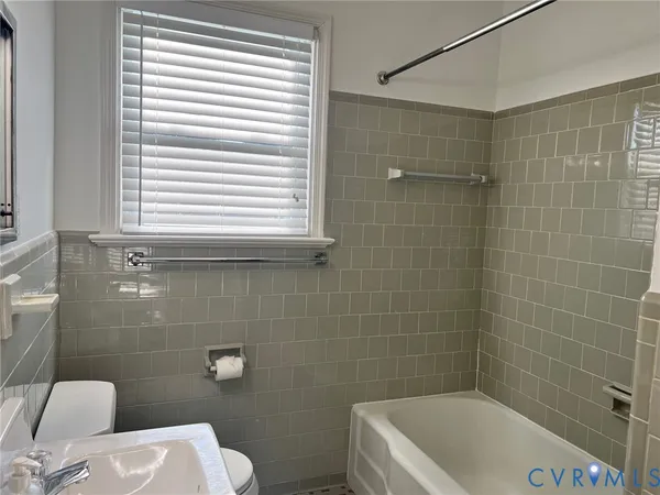 a bathroom with a toilet a sink and bathtub