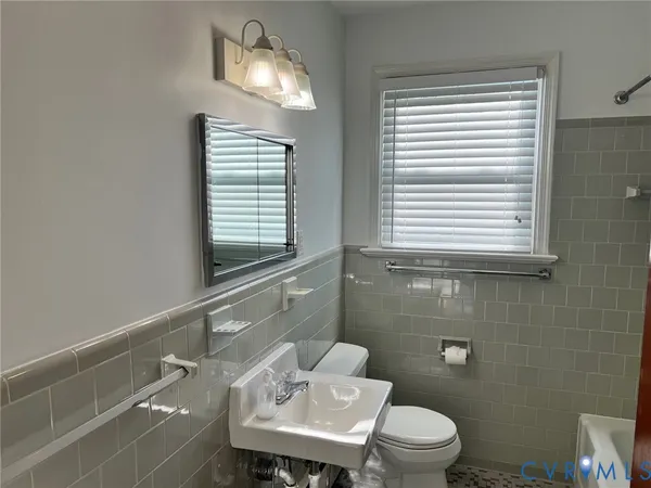 a bathroom with a toilet a sink and a mirror