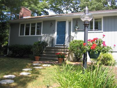 8 Quamhassett Road Buzzards Bay, MA 02532 - Photo 3 of 30 a view of a house with potted plants and a table and chairs