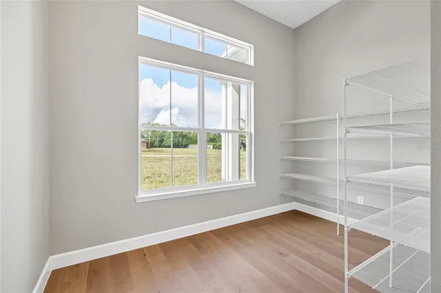 a dining room with furniture potted plants and wooden floor