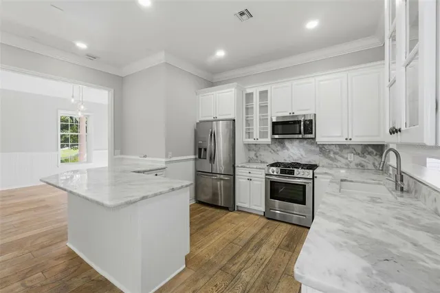 a view of a livingroom with an empty space & wooden floor