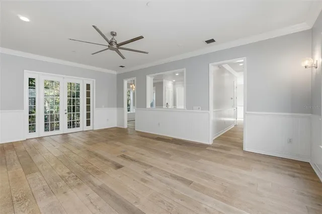 a view of an empty room with window and wooden floor