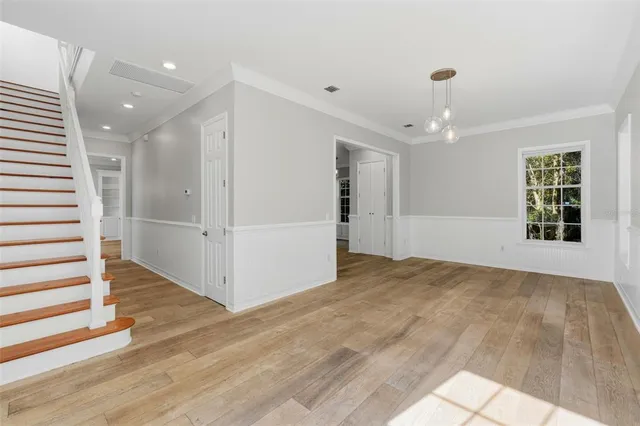 a large white kitchen with kitchen island a sink stainless steel appliances and cabinets