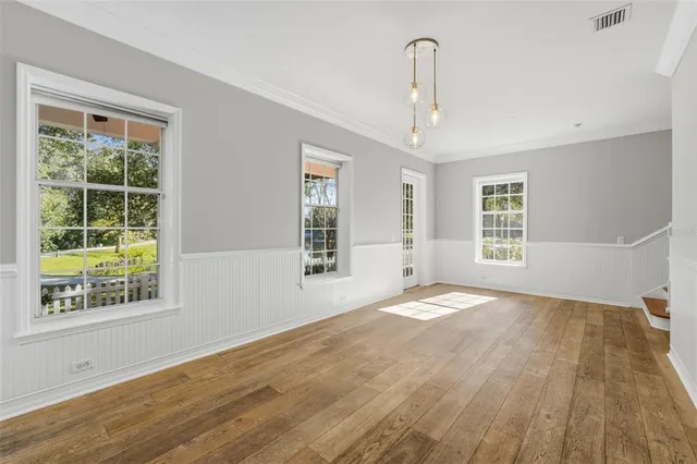 a view of an empty room with a kitchen stove and wooden floor