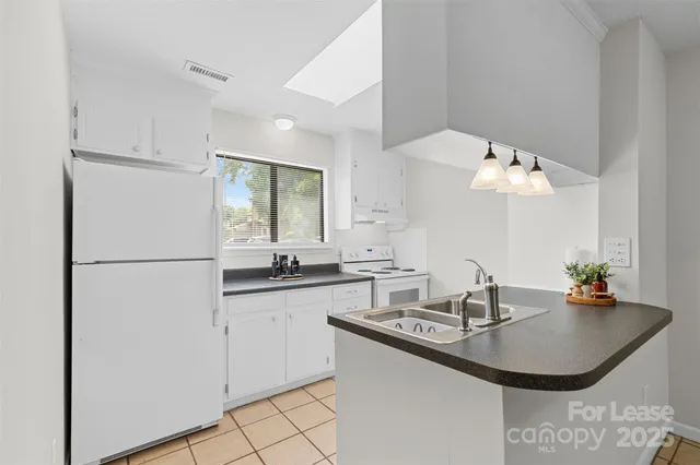 a kitchen with granite countertop a sink a refrigerator and a stove