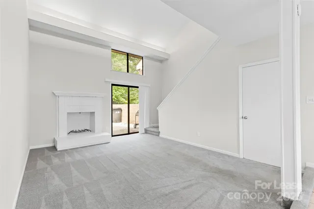 an empty room with windows and mirror