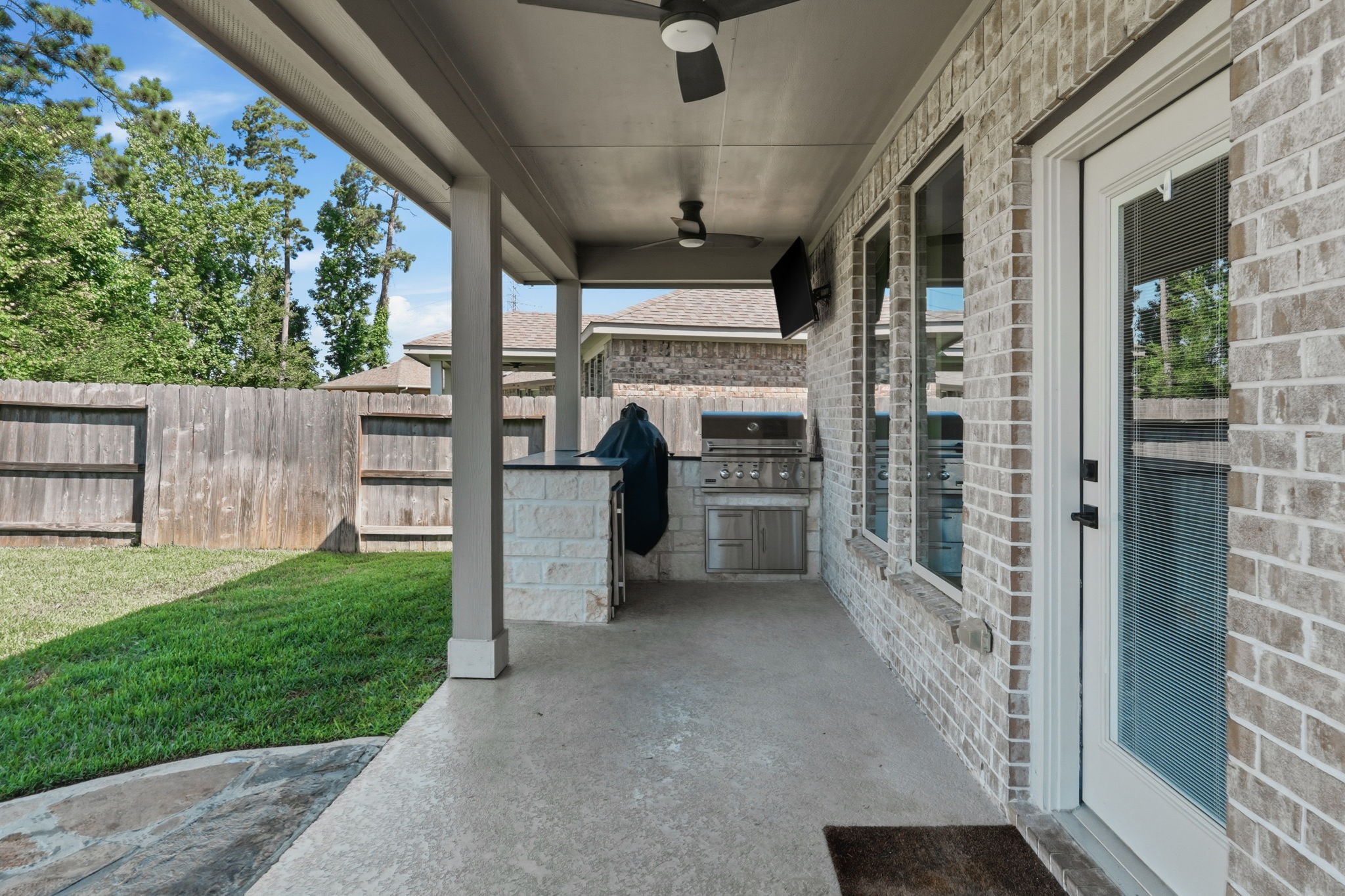 4334 Umber Shadow Drive Spring, TX 77386 - Photo 33 of 45 Covered outdoor living area features a ceiling fan, concrete patio, and a built-in outdoor kitchen for effortless entertaining.